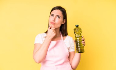 Genç ve güzel bir kadın. Düşünüyor, kuşkulu ve şaşkın hissediyor. Zeytinyağlı ev aşçısı