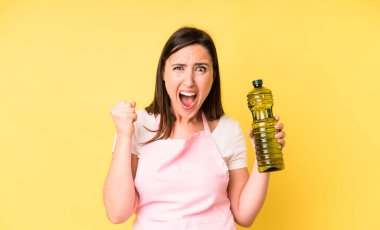 Genç ve güzel bir kadın sinirli bir ifadeyle agresif bir şekilde bağırıyor. Zeytinyağlı ev aşçısı