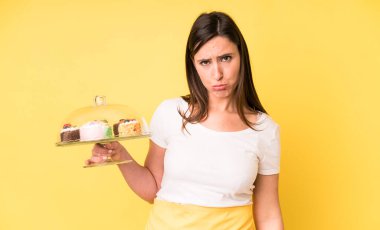 Genç ve güzel bir kadın üzgün ve mızmızlanıyor. Mutsuz bir bakışı var ve ağlıyor. Ev yapımı kek konsepti