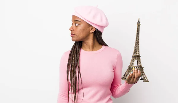 young adult black woman on profile view thinking, imagining or daydreaming. france concept