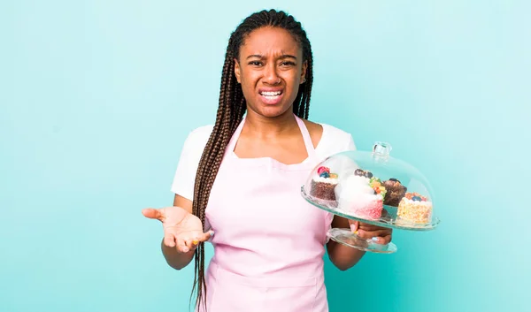young adult black woman looking angry, annoyed and frustrated. home made cakes concept