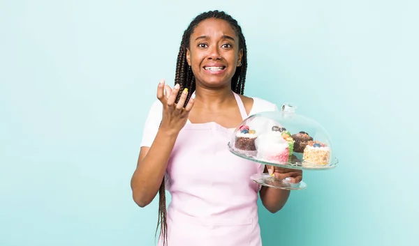 young adult black woman looking desperate, frustrated and stressed. home made cakes concept