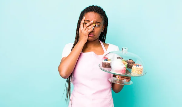 young adult black woman feeling bored, frustrated and sleepy after a tiresome. home made cakes concept