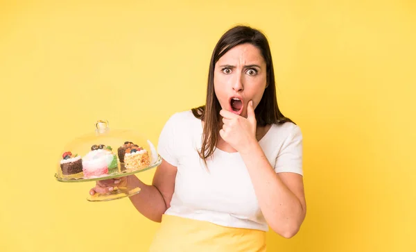 口と目が広い若い大人の可愛い女が顎を開いて手をつないでる 自家製ケーキのコンセプト — ストック写真