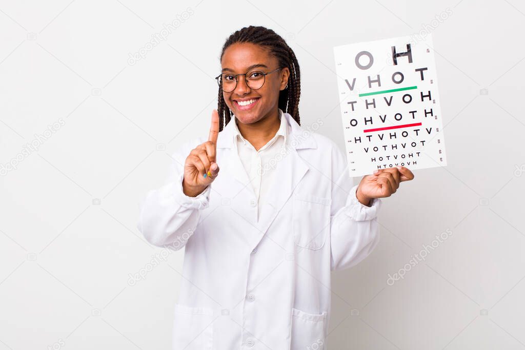 young adult black woman smiling proudly and confidently making number one. optical vision test concept