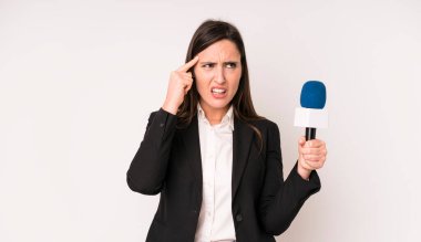 Genç ve güzel bir kadın kafası karışık ve şaşkın hissediyor. Deli olduğunu gösteriyor. Bir mikrofon konseptine sahip sunucu