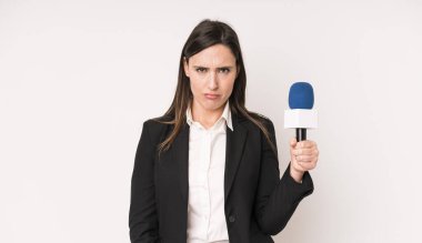 Genç ve güzel bir kadın şaşkın ve şaşkın hissediyor. Bir mikrofon konseptine sahip sunucu