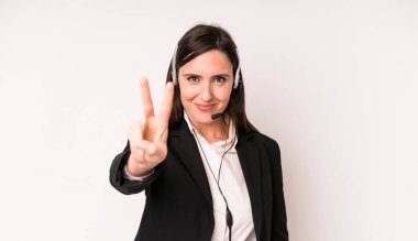 Genç ve güzel bir kadın gülümsüyor ve arkadaş canlısı görünüyor. İki numarayı gösteriyor. tele pazarlamacı kavramı