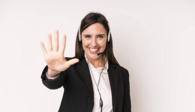 Genç ve güzel bir kadın gülümsüyor ve arkadaş canlısı görünüyor. Beş numarayı gösteriyor. tele pazarlamacı kavramı