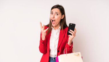 Genç ve güzel bir kadın son derece şaşkın ve şaşırmış hissediyor. Alışveriş torbaları konsepti