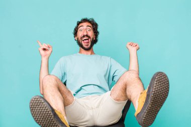 Genç, İspanyol asıllı, deli adam sandalyede oturuyor.