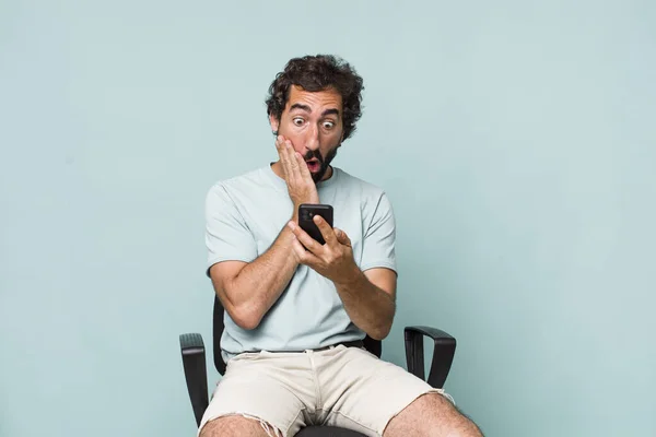 Young Adult Hispanic Crazy Man Using His Phone Sitting Chair — Stock Photo, Image