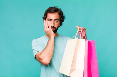 Genç, Latin, deli bir adam. Alışveriş torbaları konsepti
