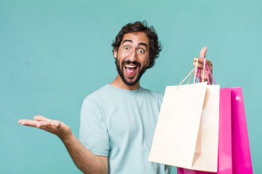 Genç, Latin, deli bir adam. Alışveriş torbaları konsepti