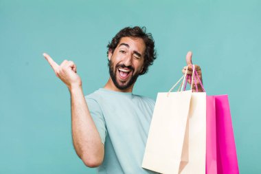 Genç, Latin, deli bir adam. Alışveriş torbaları konsepti