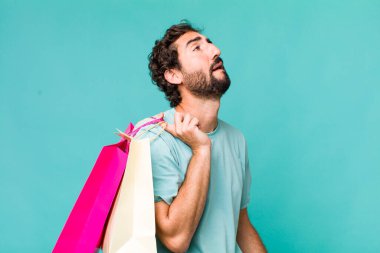 Genç, Latin, deli bir adam. Alışveriş torbaları konsepti