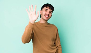 Genç, İspanyol asıllı, mutlu ve neşeli bir şekilde gülümseyen, el sallayan, seni selamlayan, ya da hoşça kal diyen adam.