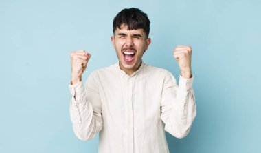 Genç, İspanyol asıllı bir adam mutlu, şaşırmış ve gururlu hisseder, bağırır ve başarıyı büyük bir gülümsemeyle kutlar.