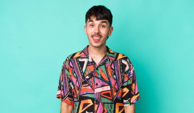 Genç, İspanyol bir adam mutlu ve hoş bir şekilde şaşırmış görünüyor. Büyülenmiş ve şok olmuş bir ifadeyle heyecanlanıyor.