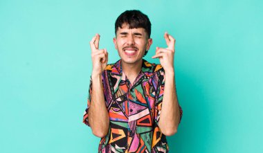 Genç, Latin bir adam gergin ve umutlu. Dua ediyor ve şans diliyor.