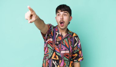 Genç, İspanyol bir adam şok olmuş ve şaşırmış hissediyor. Şaşırmış ve ağzı açık bir şekilde hayranlıkla yukarı bakıyor.