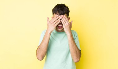 Genç, Latin asıllı, gülümseyen ve mutlu hisseden bir adam. İki eliyle gözlerini kapatıyor ve inanılmaz bir sürpriz bekliyor.