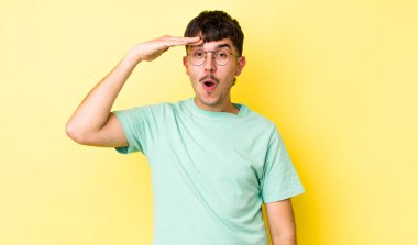 Genç, yetişkin İspanyol adam mutlu, şaşkın ve şaşırmış görünüyor, gülümsüyor ve inanılmaz ve inanılmaz iyi haberleri fark ediyor.