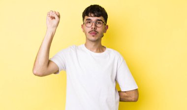 Genç, Latin asıllı, ciddi, güçlü ve isyankar bir adam yumruğunu kaldırıyor, protesto ediyor ya da devrim için savaşıyor.