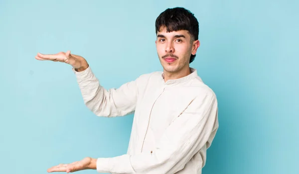 Young Adult Hispanic Man Holding Object Both Hands Side Copy — Stock Photo, Image