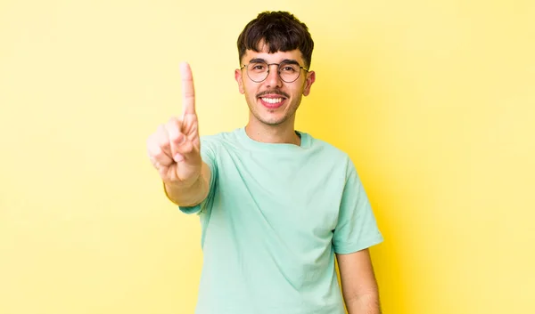 Joven Adulto Hispano Sonriendo Luciendo Amigable Mostrando Número Uno Primero —  Fotos de Stock