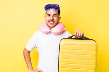 Genç İspanyol adam mutlu bir şekilde gülümsüyor, eli kalçasında ve kendinden emin. seyahat kavramı