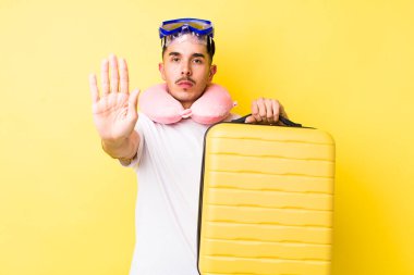 Genç İspanyol adam ciddi görünüyor. Avuç içi gösteriyor. Durdurma hareketi yapıyor. seyahat kavramı