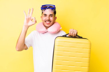 Genç İspanyol adam kendini mutlu hissediyor, iyi bir jestle onaylıyor. seyahat kavramı