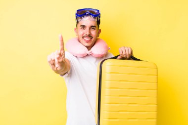 Genç İspanyol adam gururla gülümsüyor ve kendinden emin bir numara oluyor. seyahat kavramı