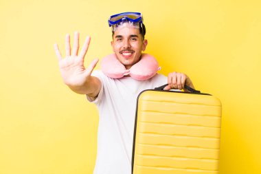 Genç İspanyol adam gülümsüyor ve arkadaş canlısı görünüyor, beş numarayı gösteriyor. seyahat kavramı