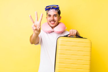 Genç İspanyol adam gülümsüyor ve arkadaş canlısı görünüyor, üç numarayı gösteriyor. seyahat kavramı