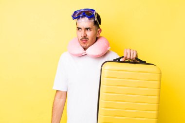 Genç İspanyol bir adam üzgün, üzgün ya da kızgın hissediyor ve yan tarafa bakıyor. seyahat kavramı