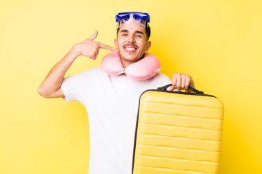 Genç İspanyol adam kendine güvenerek gülümsüyor ve kendi gülüşünü gösteriyor. seyahat kavramı