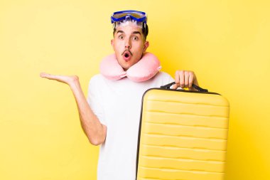 Genç İspanyol bir adam şaşırmış ve şok olmuş görünüyor. Çenesi düşmüş ve elinde bir nesne tutuyor. seyahat kavramı