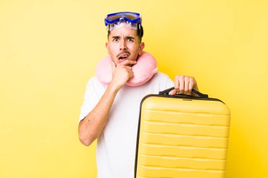 Ağzı ve gözleri sonuna kadar açık ve eli çenesinde genç İspanyol bir adam. seyahat kavramı