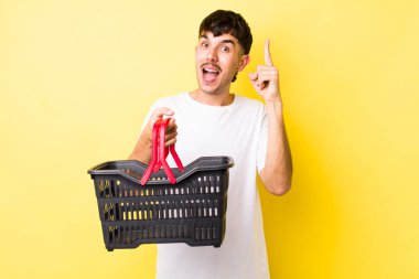 Genç İspanyol bir adam bir fikri fark ettikten sonra mutlu ve heyecanlı bir dahi gibi hissediyor. boş alışveriş sepeti kavramı