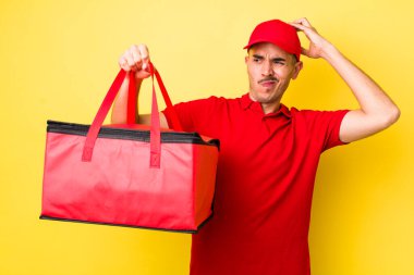 Genç İspanyol adam şaşkın ve kafası karışık, kaşınan bir kafa hissediyor. Pizza dağıtımı kavramı