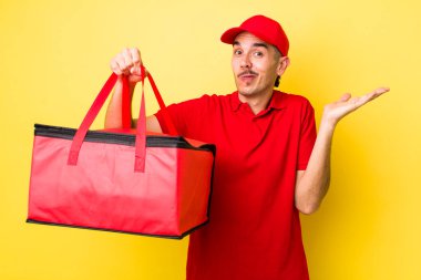 Genç İspanyol adam şaşkın, şaşkın ve şüpheci hissediyor. Pizza dağıtımı kavramı