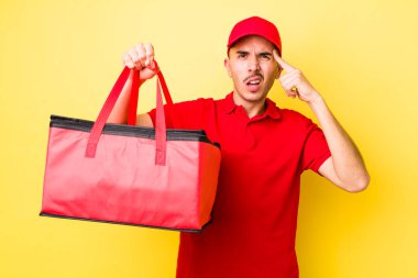 Genç İspanyol adam şaşkın ve şaşkın hissediyor, senin deli olduğunu gösteriyor. Pizza dağıtımı kavramı