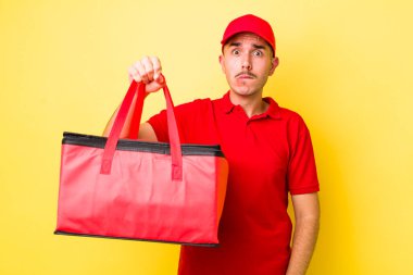 Genç İspanyol adam şaşkın ve şaşkın görünüyor. Pizza dağıtımı kavramı