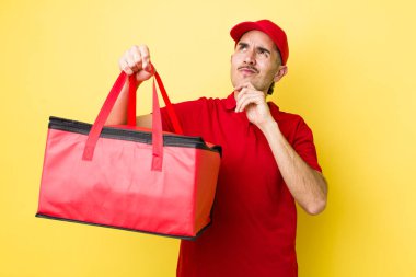 Genç İspanyol adam düşünüyor, kuşkulu ve şaşkın hissediyor. Pizza dağıtımı kavramı