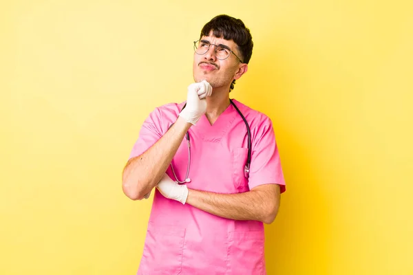 Young Hispanic Man Thinking Feeling Doubtful Confused Veterinarian Concept — Stock Photo, Image