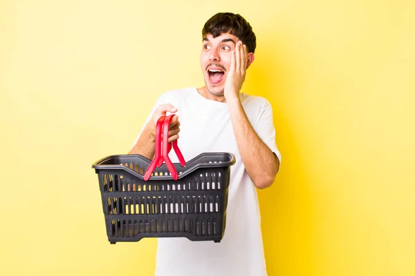 Young Hispanic Man Feeling Happy Excited Surprised Empty Shopping Basket — Stock Photo, Image