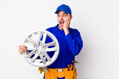 İspanyol adam mutlu, heyecanlı ve şaşırmış hissediyor. araba mekaniği kavramı