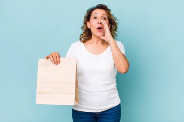 Orta yaşlı bir kadın kendini mutlu hissediyordu. Elleri ağzının kenarında bağırıyordu. konsepti kaldır